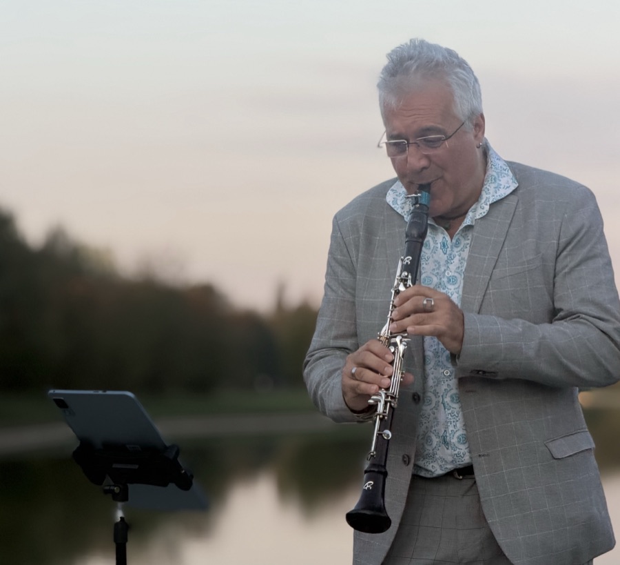Stefano Corradi playing the clarinet, reading from a tablet